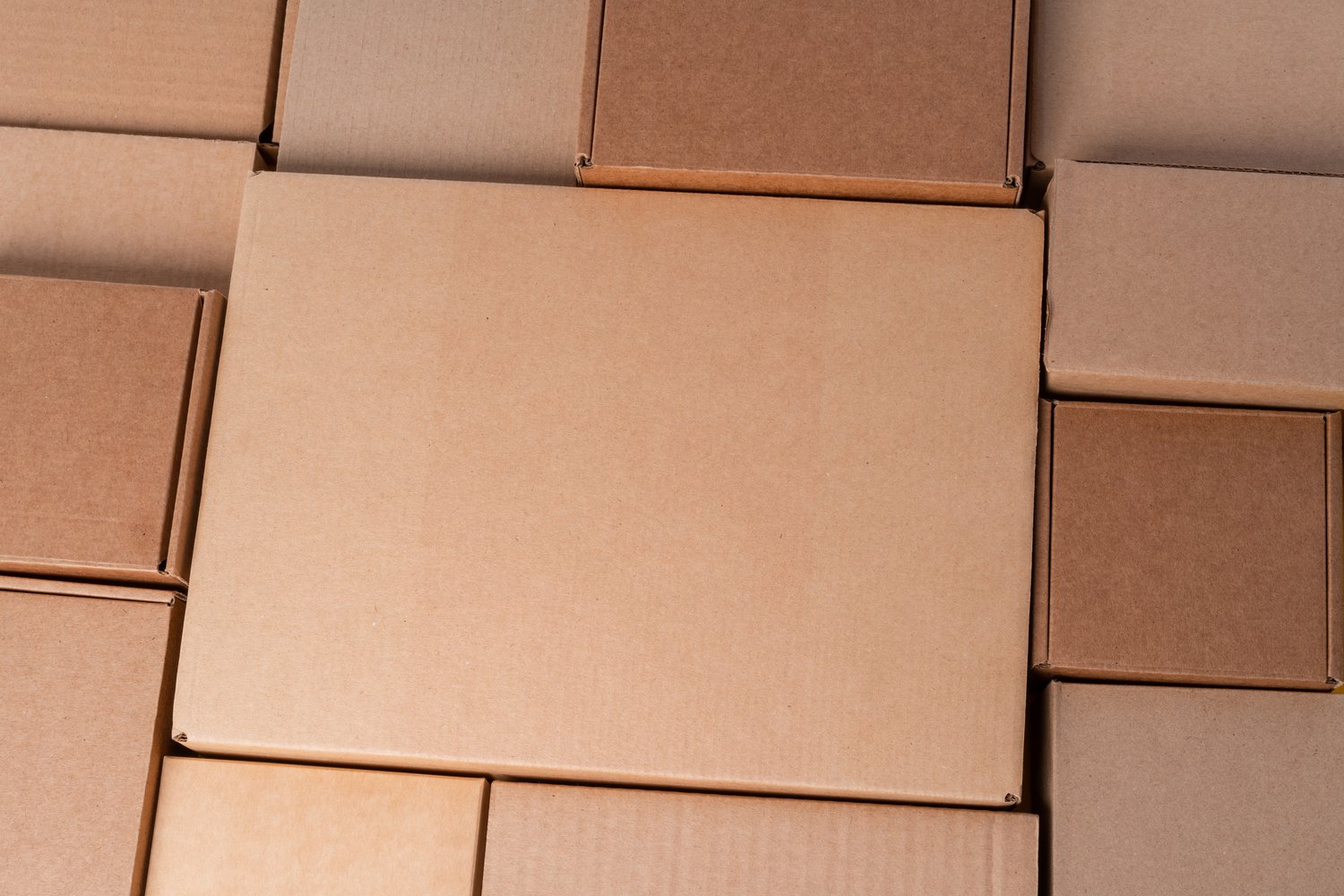 Cardboard boxes stacked in a pile as a background, close up