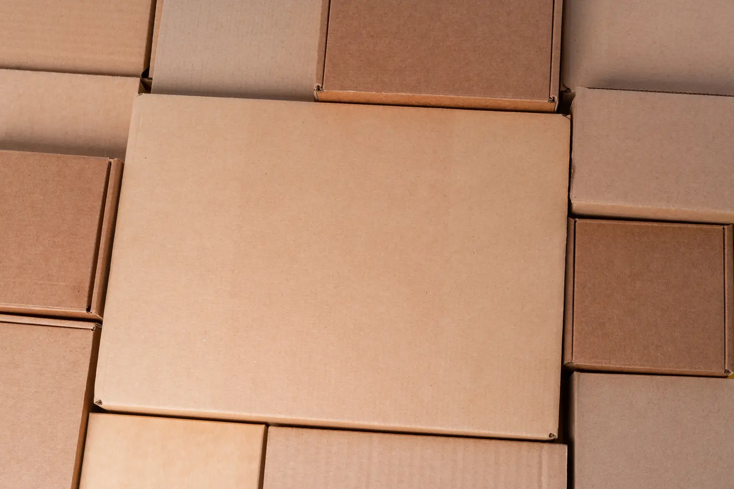 Cardboard boxes stacked in a pile as a background, close up